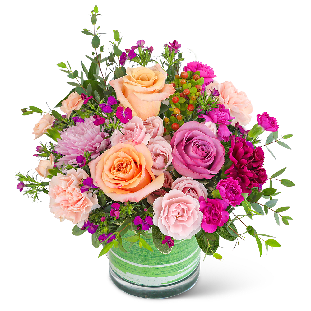 Mixed bouquet of peach, pink, and purple flowers in a green glass vase