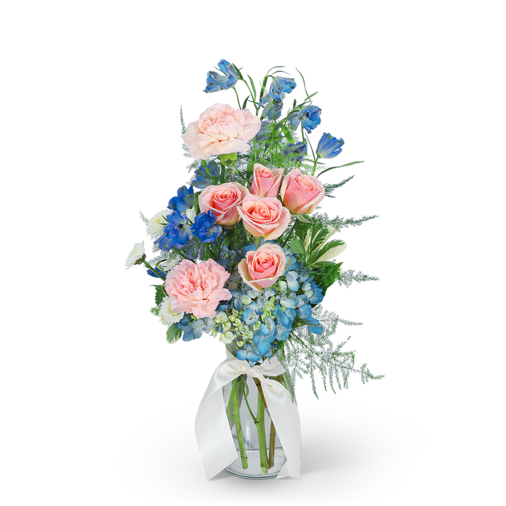 Pink roses and blue flowers in a glass vase with a white ribbon