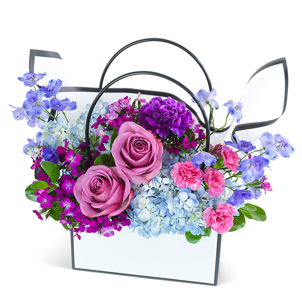 Mixed bouquet in a white handled basket with pink roses and blue flowers
