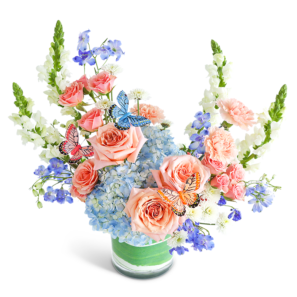 Peach roses and blue hydrangeas in a glass vase with butterfly accents
