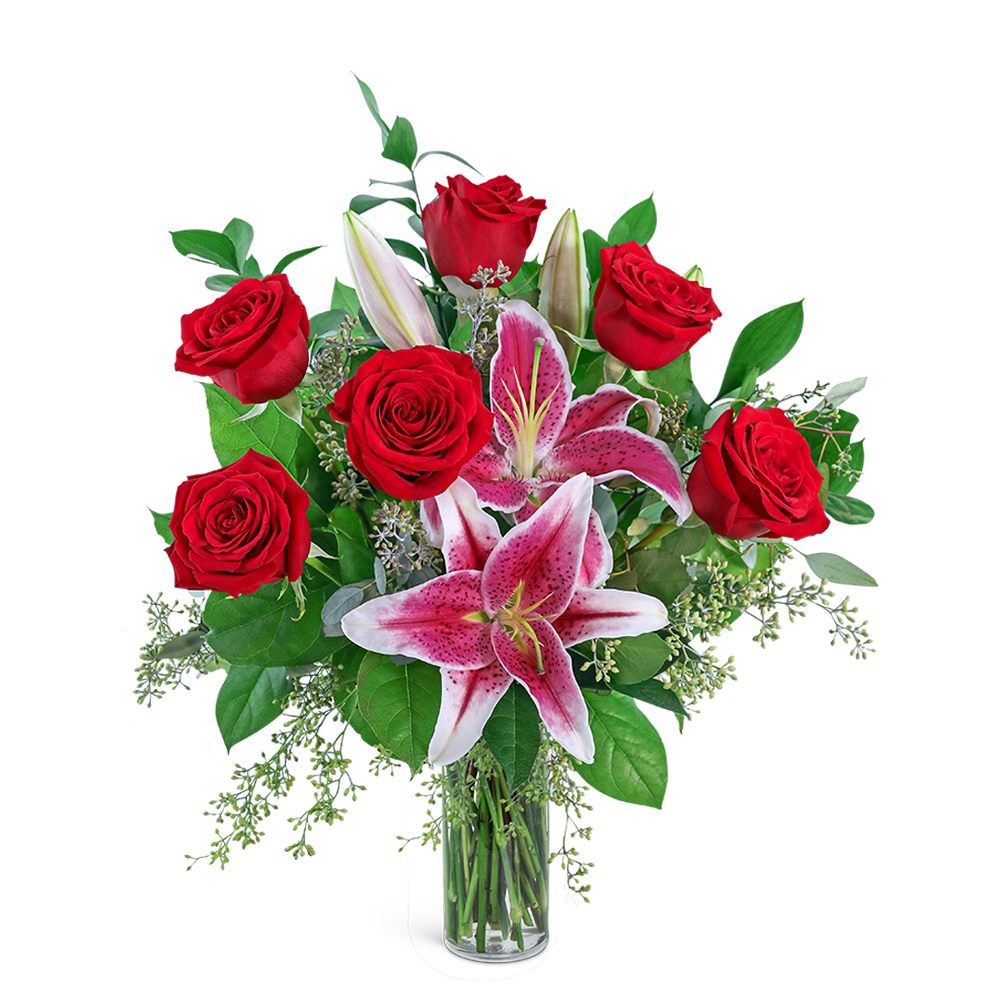 Red roses and pink lilies in a clear glass vase