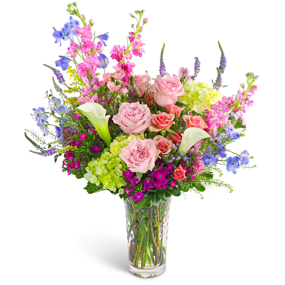 Mixed bouquet of pink roses, calla lilies, and blue flowers in a clear vase