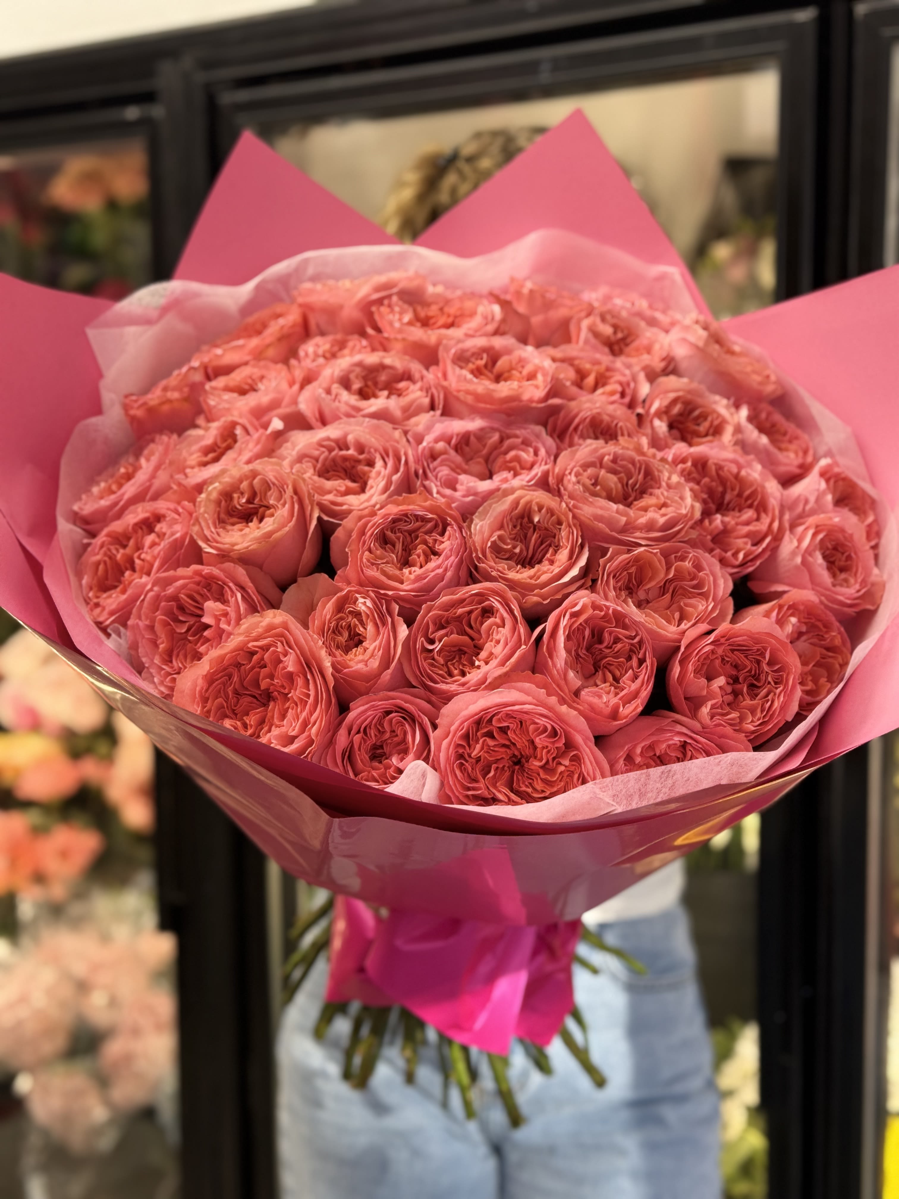 Large bouquet of pink roses wrapped in bright pink paper