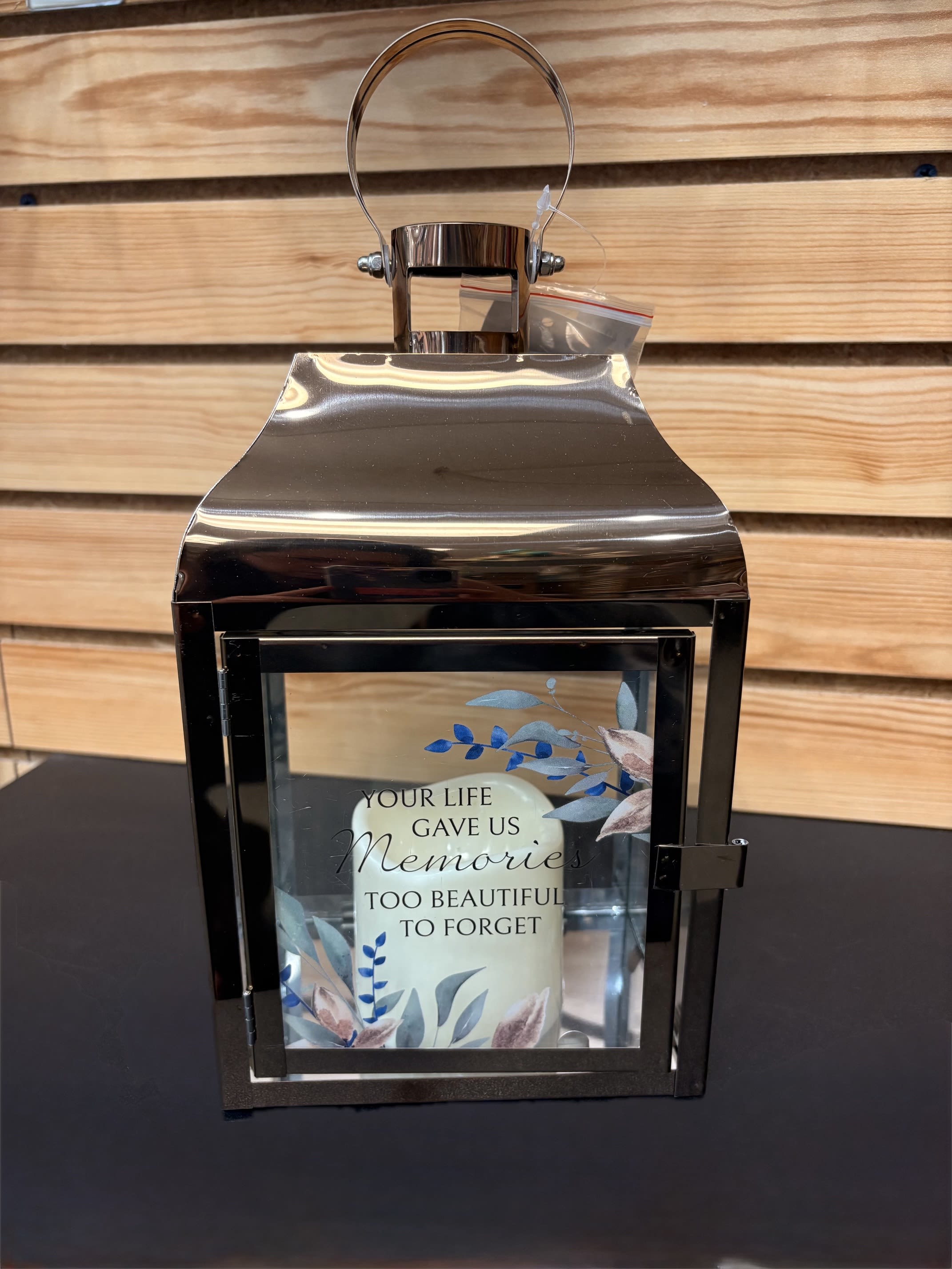 Lantern - Copper Memories - These lanterns are made with a high quality metal finish and uv printed glass artwork with sentiment. The flameless LED candle features a built in automatic timer 6 hours ON/18 hours OFF. 3 AAA batteries are not included. These lanterns are intended for indoor use only.  Lantern Reads: "Your life gave us memories too beautiful to forget"  W: 6" H: 12.25" D: 4.5"