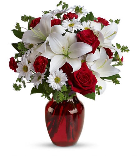 Red roses, white lilies, and daisies arranged in a red vase