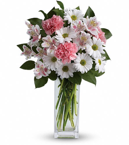 Pink carnations and white daisies in a clear glass vase