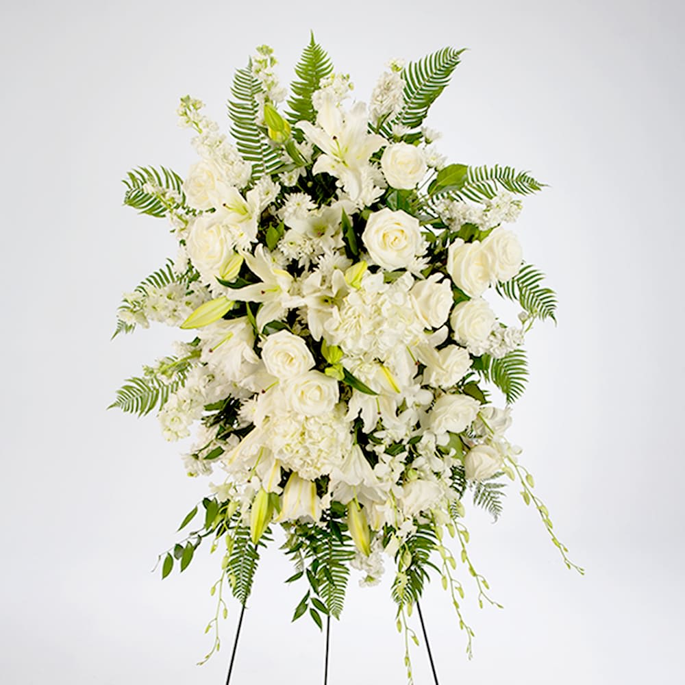 True Sympathy - An all white tribute to the passing of your loved one. Featuring a variety of white flowers and green palms this elegant funeral spray brings a feeling of peace to your services.