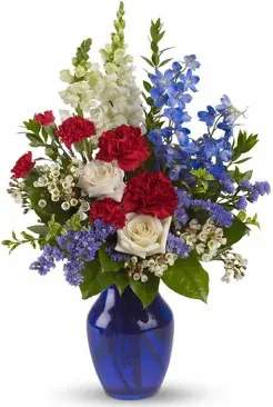 Mixed red, white, and blue flowers in a cobalt vase