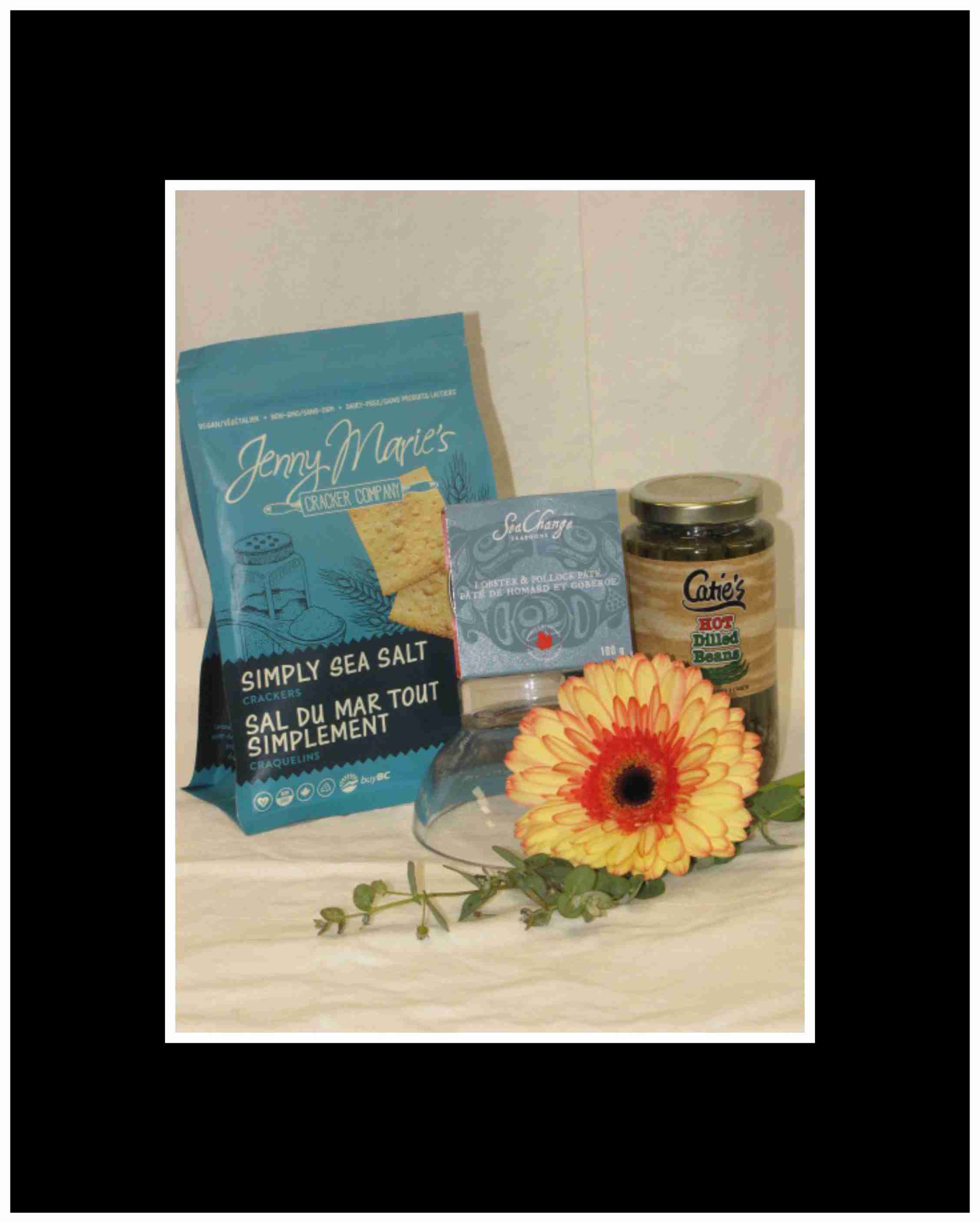 Gift basket with crackers, dip, beans, and a yellow gerbera daisy