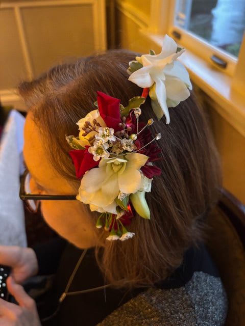 Floral hair accessory with white and red flowers worn in the hair