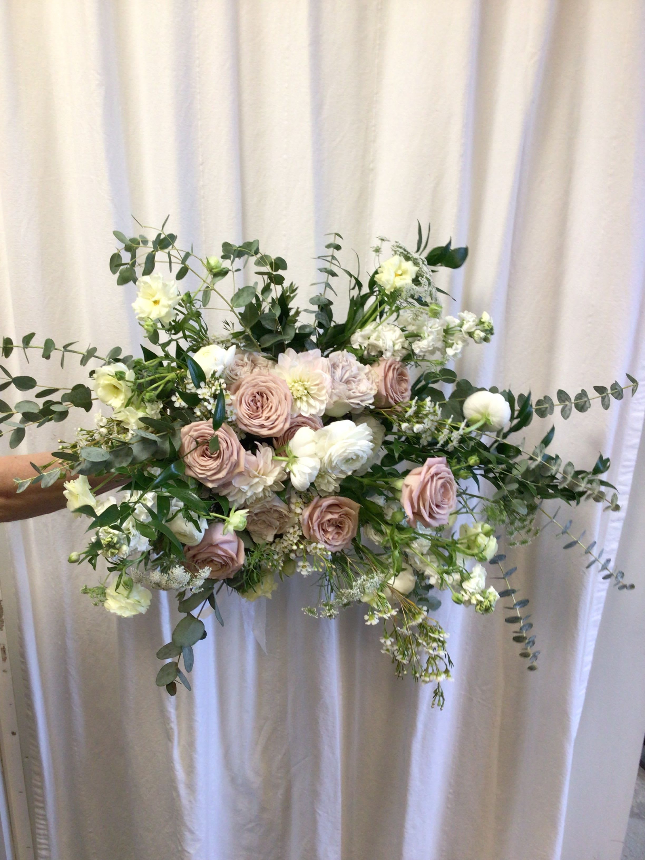 Handheld bouquet of blush roses and white flowers with airy greenery