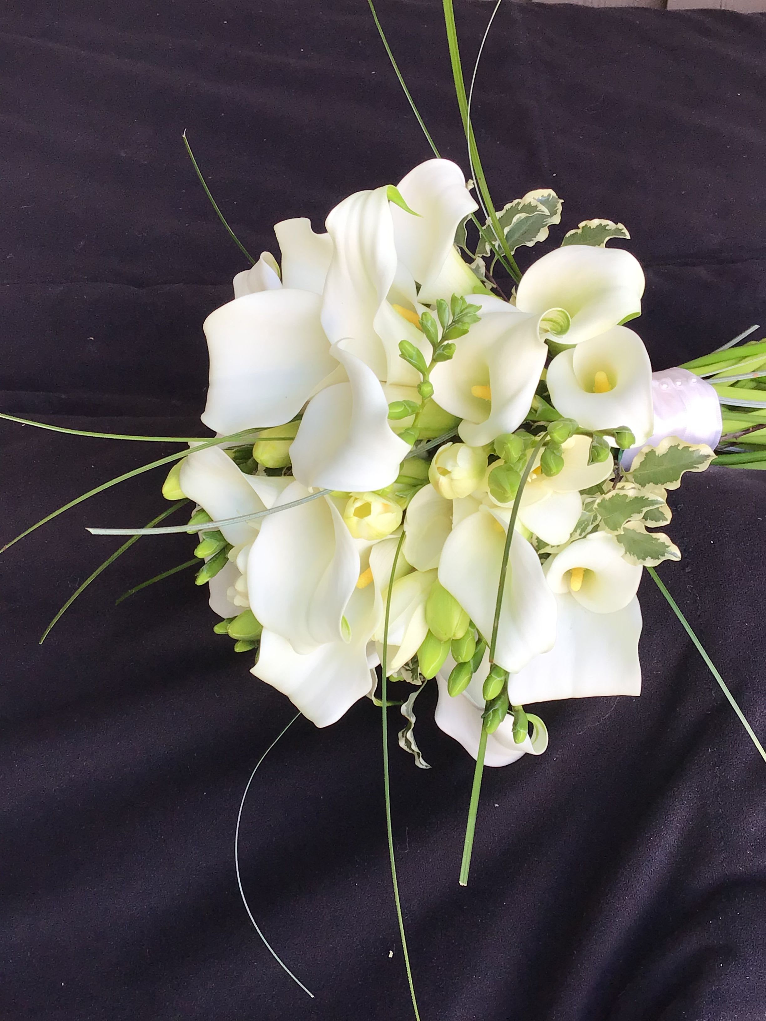 Bouquet of white calla lilies with long grass accents