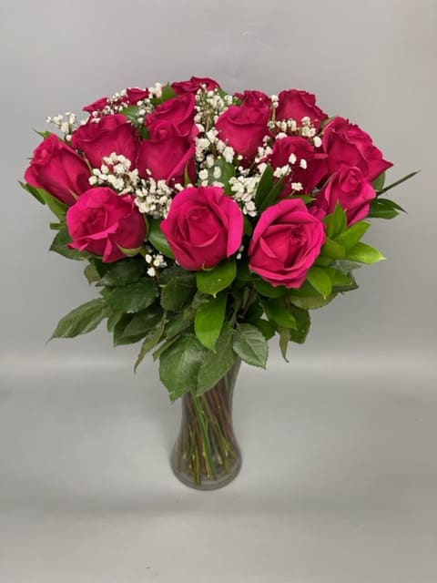 Bouquet of hot pink roses with baby's breath in a clear glass vase