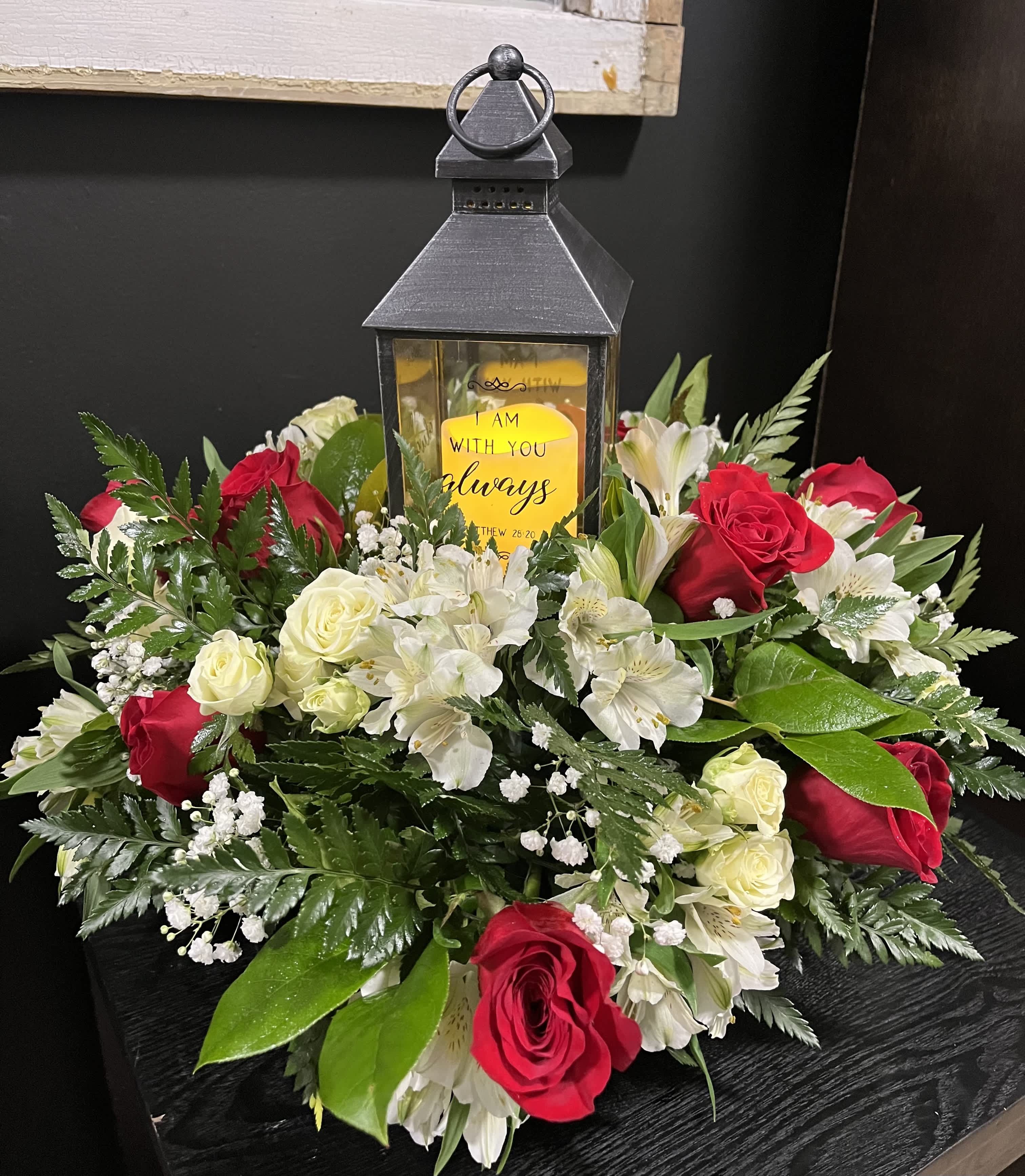 Red and white rose arrangement with a lantern centerpiece