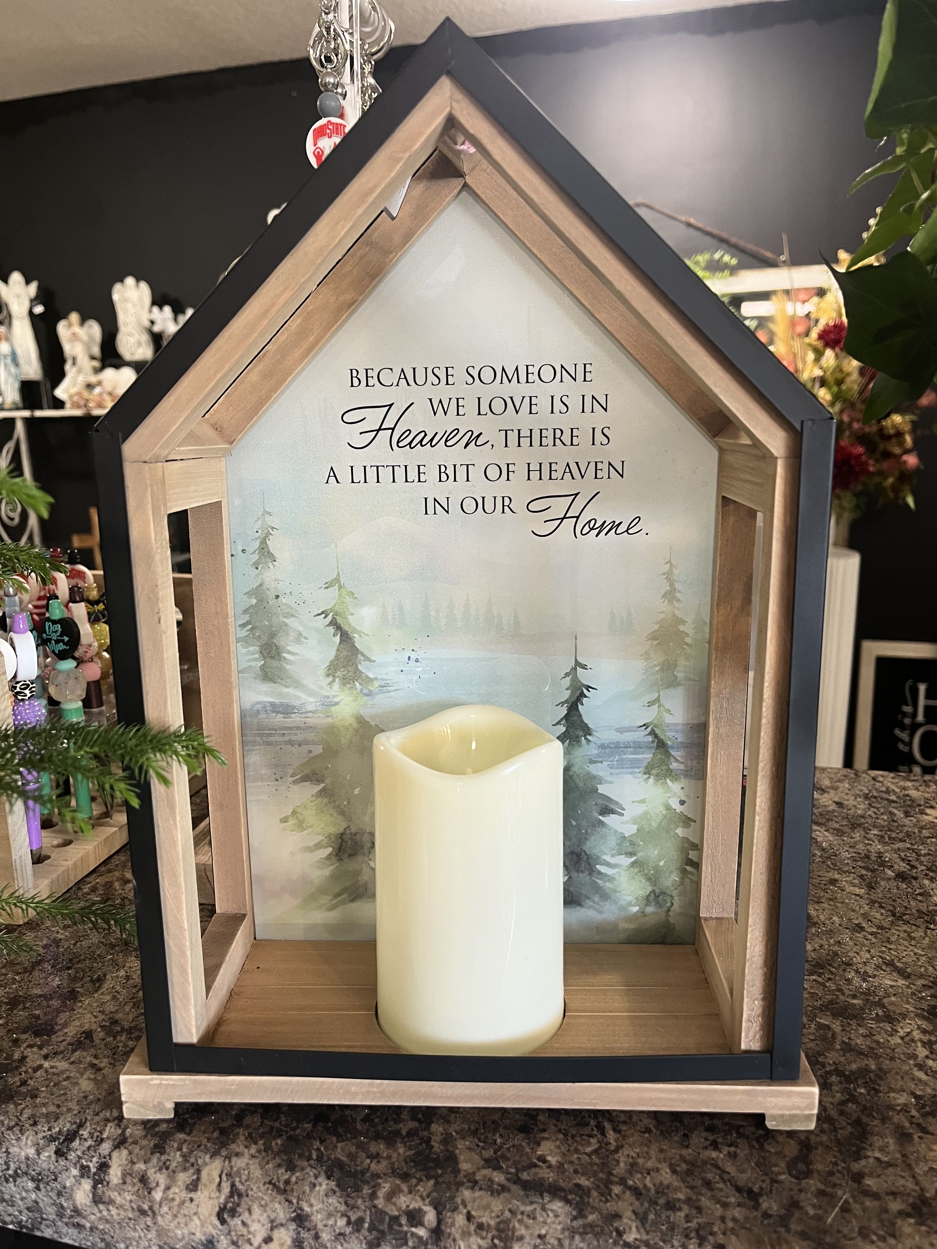 House-shaped memorial sign with a candle and sympathy message