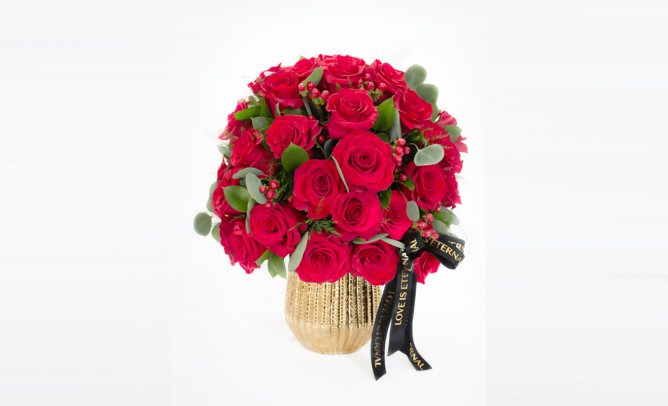 Bouquet of red roses in a gold vase with a black ribbon