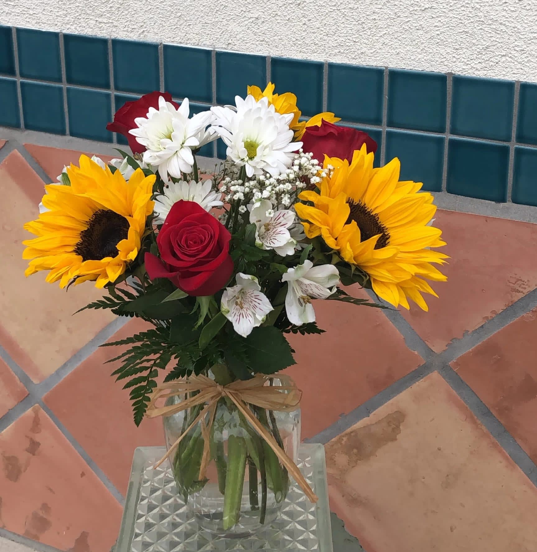 Sunflowers and Red Roses - Bright and cheerful arrangement using red roses and sunflowers with some daisy, and alstromerias. 