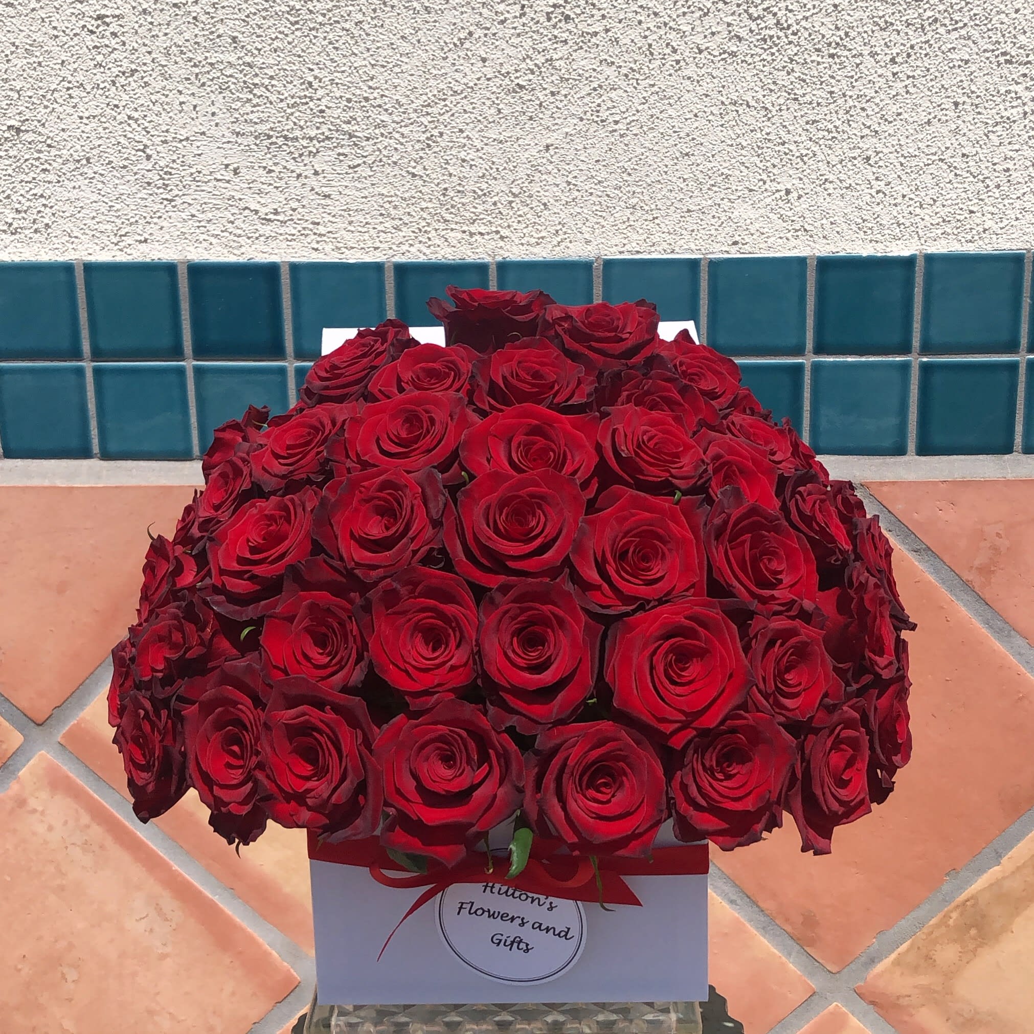 Large bouquet of red roses in a white gift box with a red ribbon