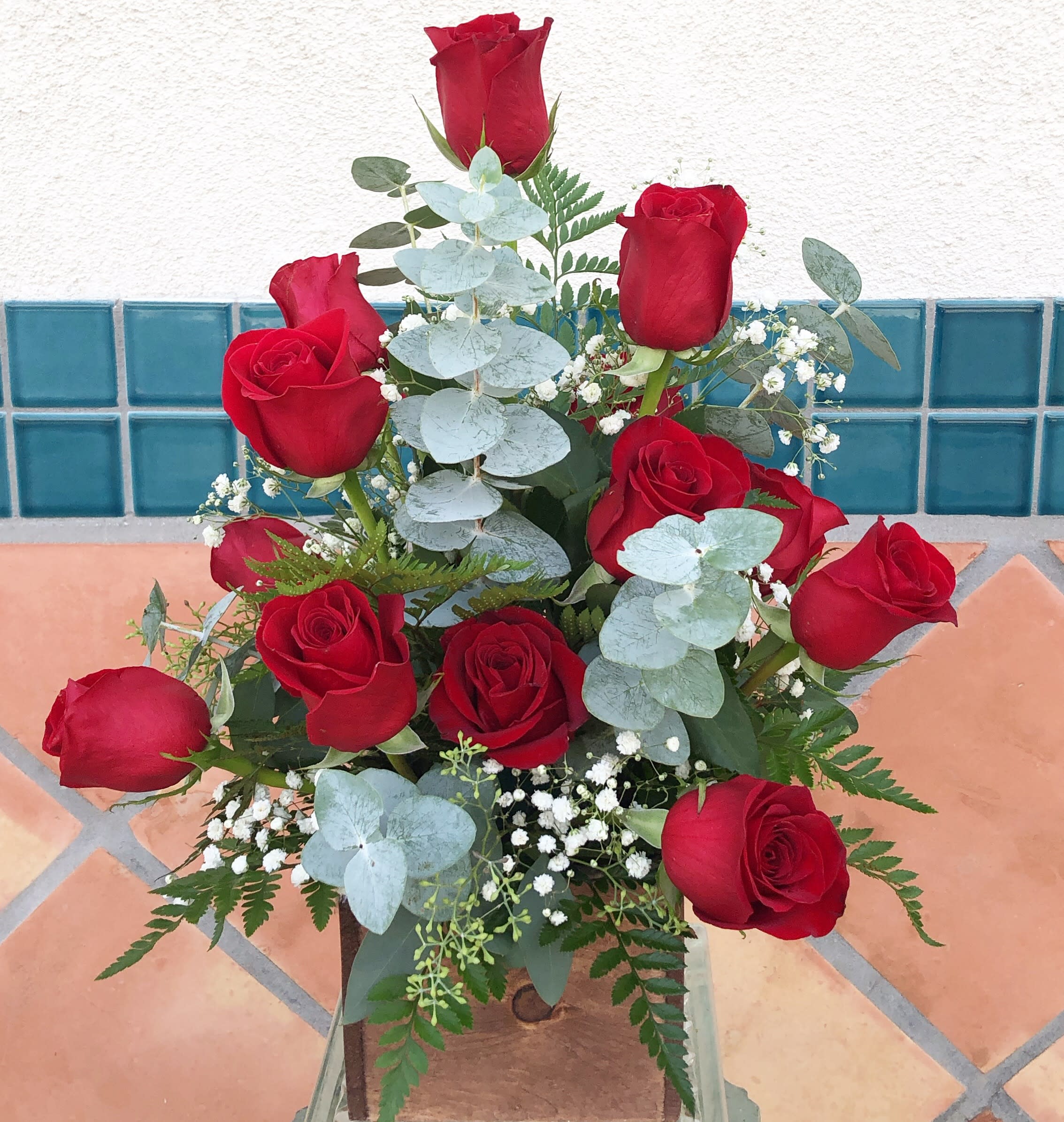 Bouquet of red roses with pale blue eucalyptus and baby's breath