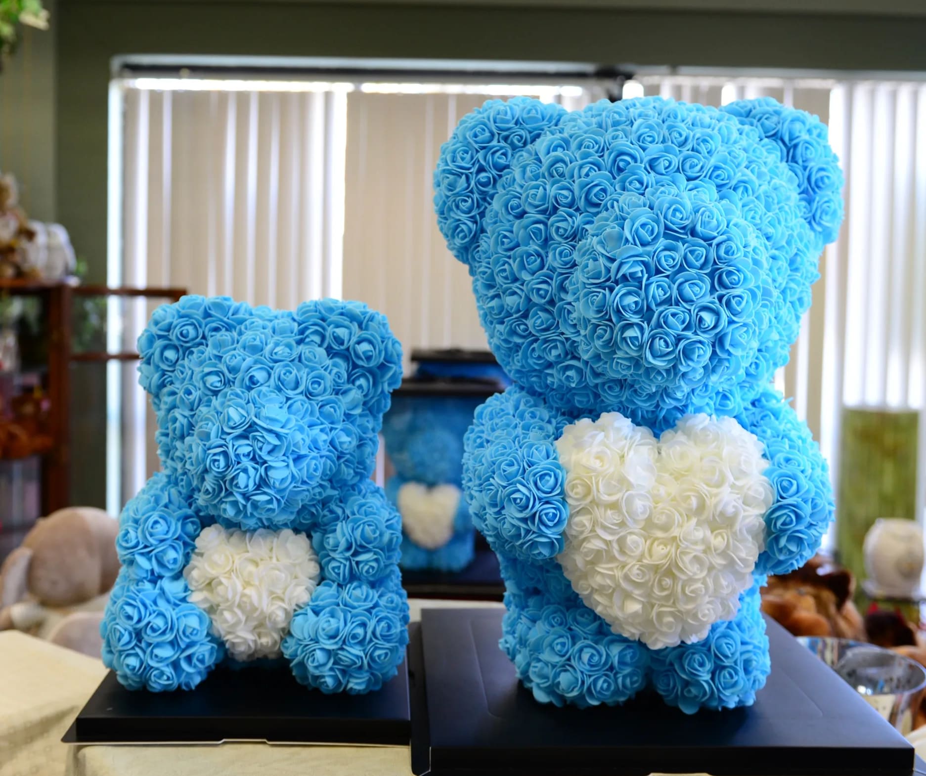 Blue Rose Bear - These gorgeous Teddy bear are made of soft synthetic fabric roses in romantic color. They come in a clear gift box. Standard: 14" tall Deluxe: 20" tall