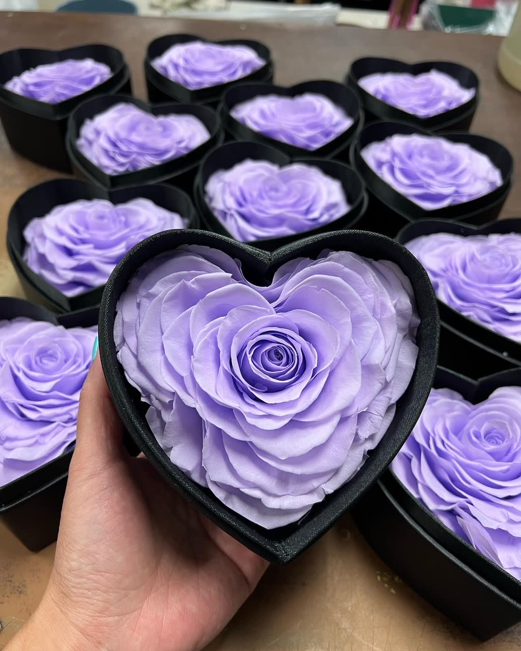 Lavender roses arranged in black heart-shaped boxes