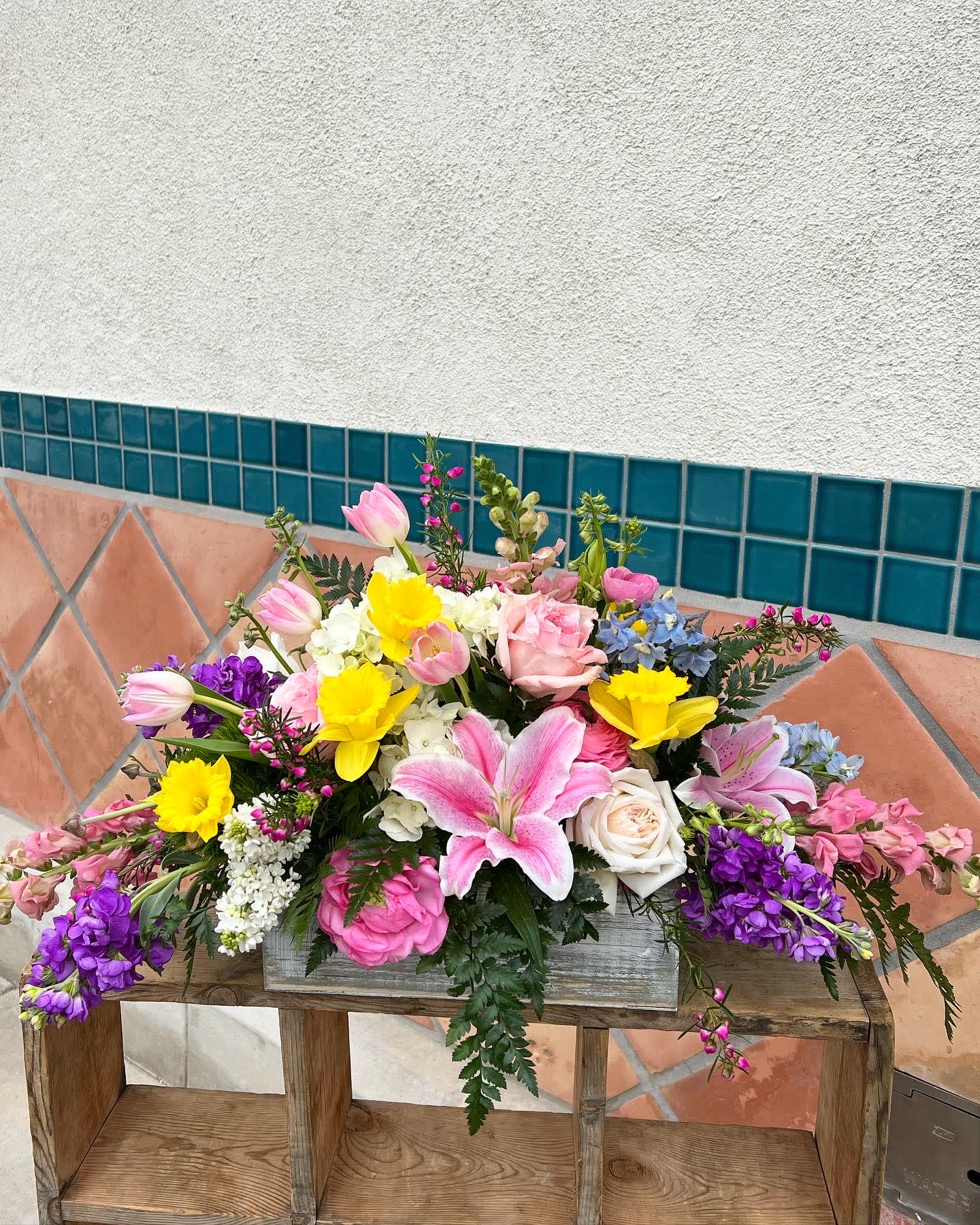 Mixed bouquet with pink tulips, roses, lilies, and yellow daffodils