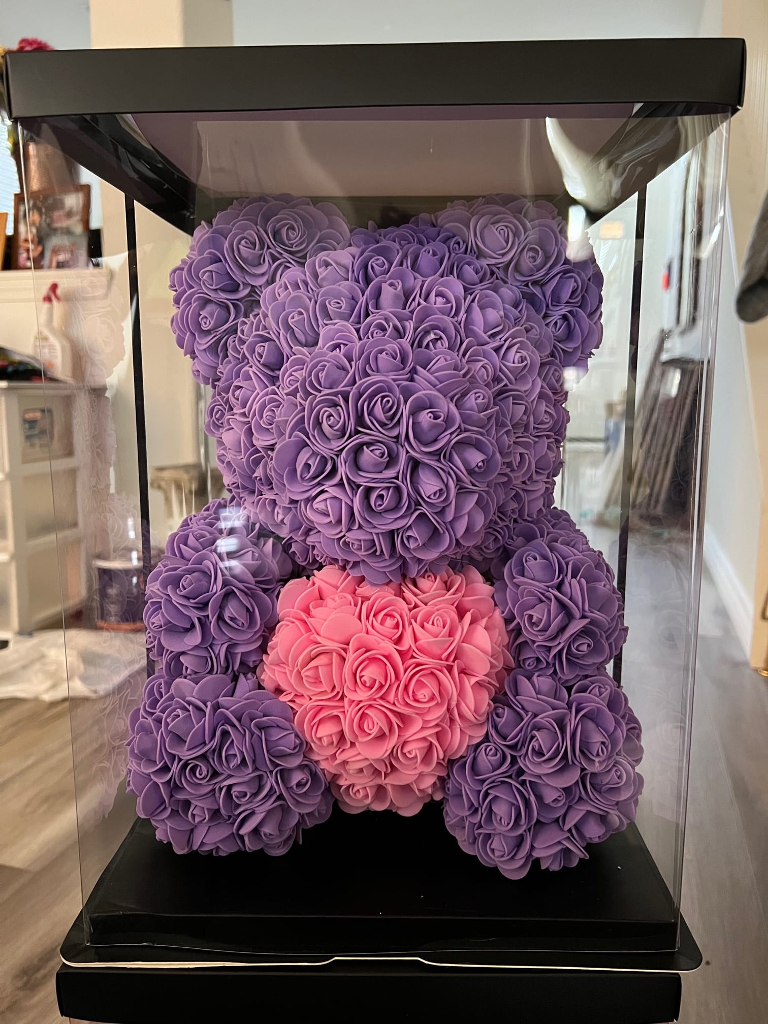 Purple and pink teddy bear made of roses inside a clear display box