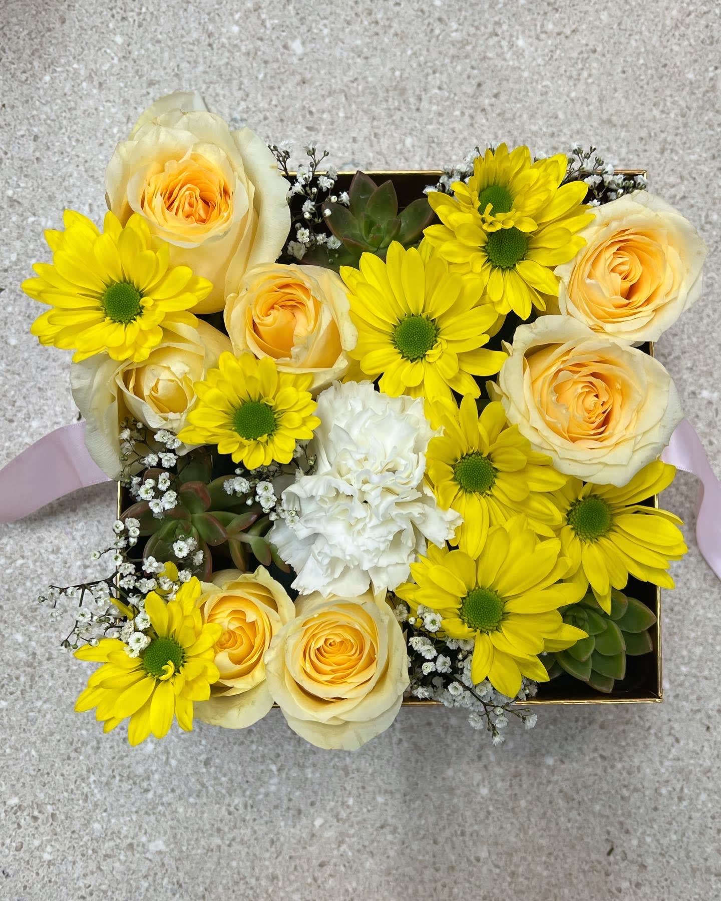 Yellow daisies and cream roses arranged in a square box