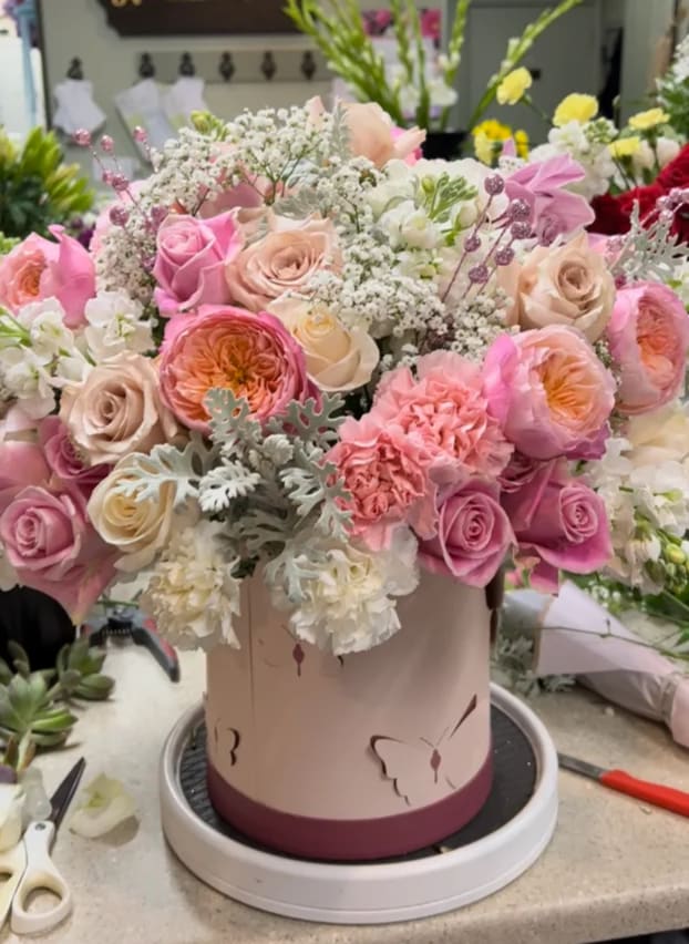 Pink and cream rose bouquet in a round hatbox