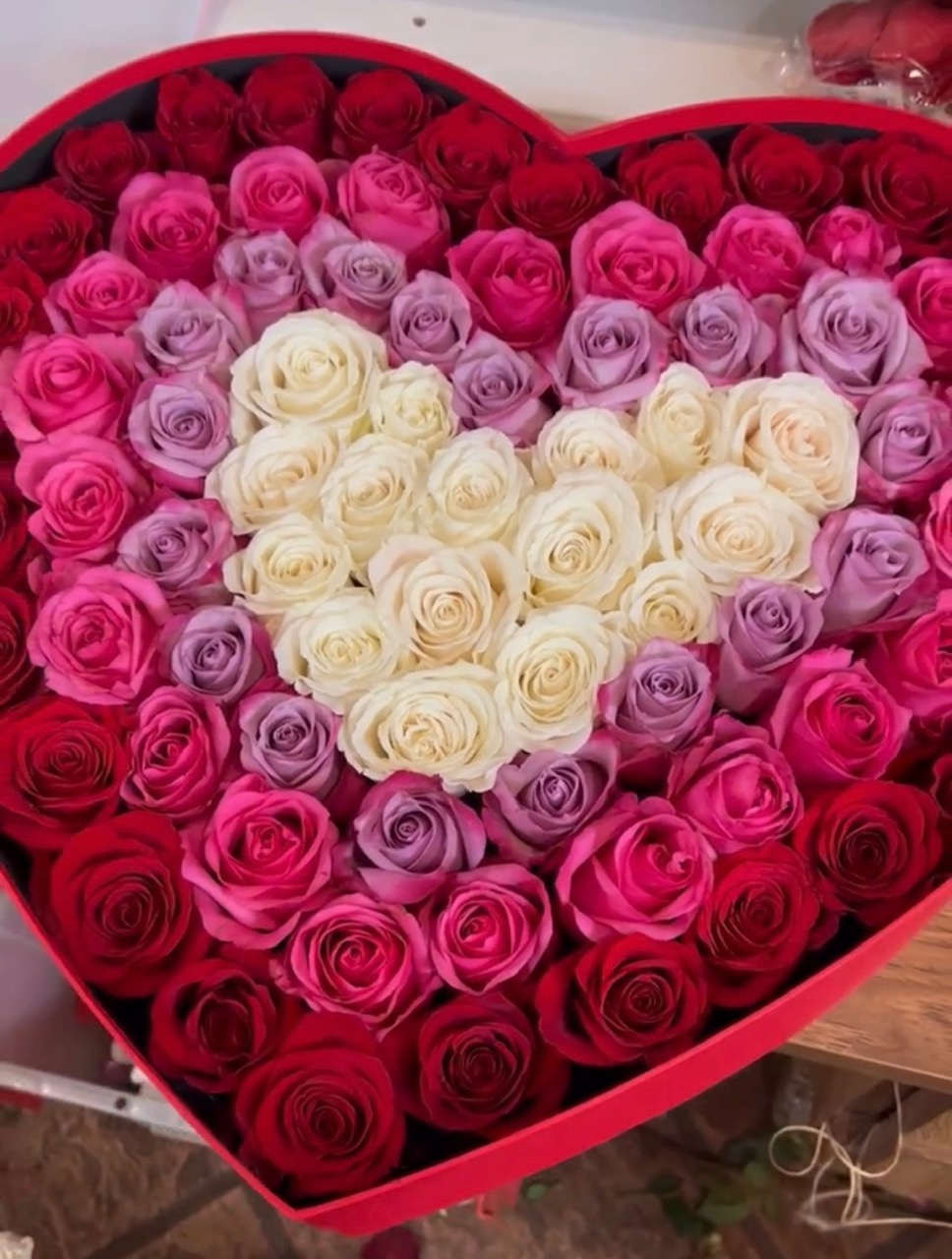 Heart-shaped box filled with red, pink, lavender, and white roses