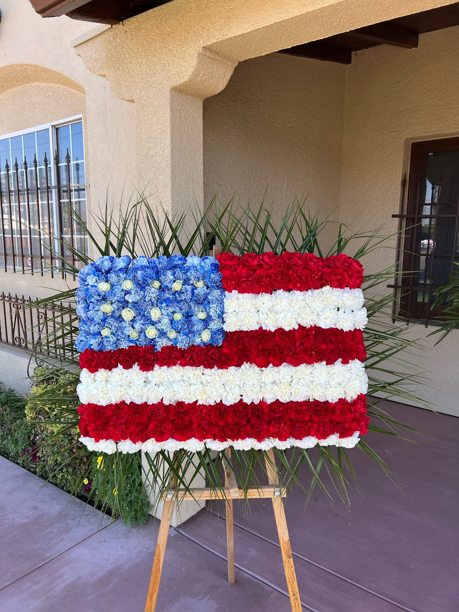 Floral arrangement shaped like the U.S. flag on an easel