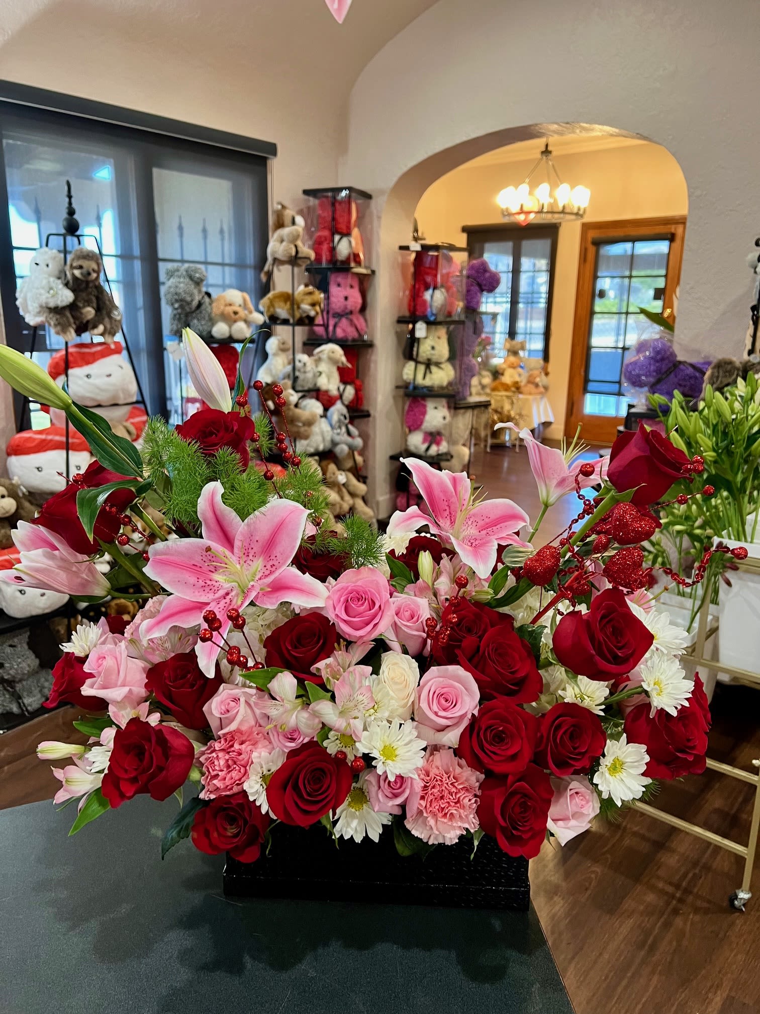 Large bouquet of red and pink roses with pink lilies in a black container