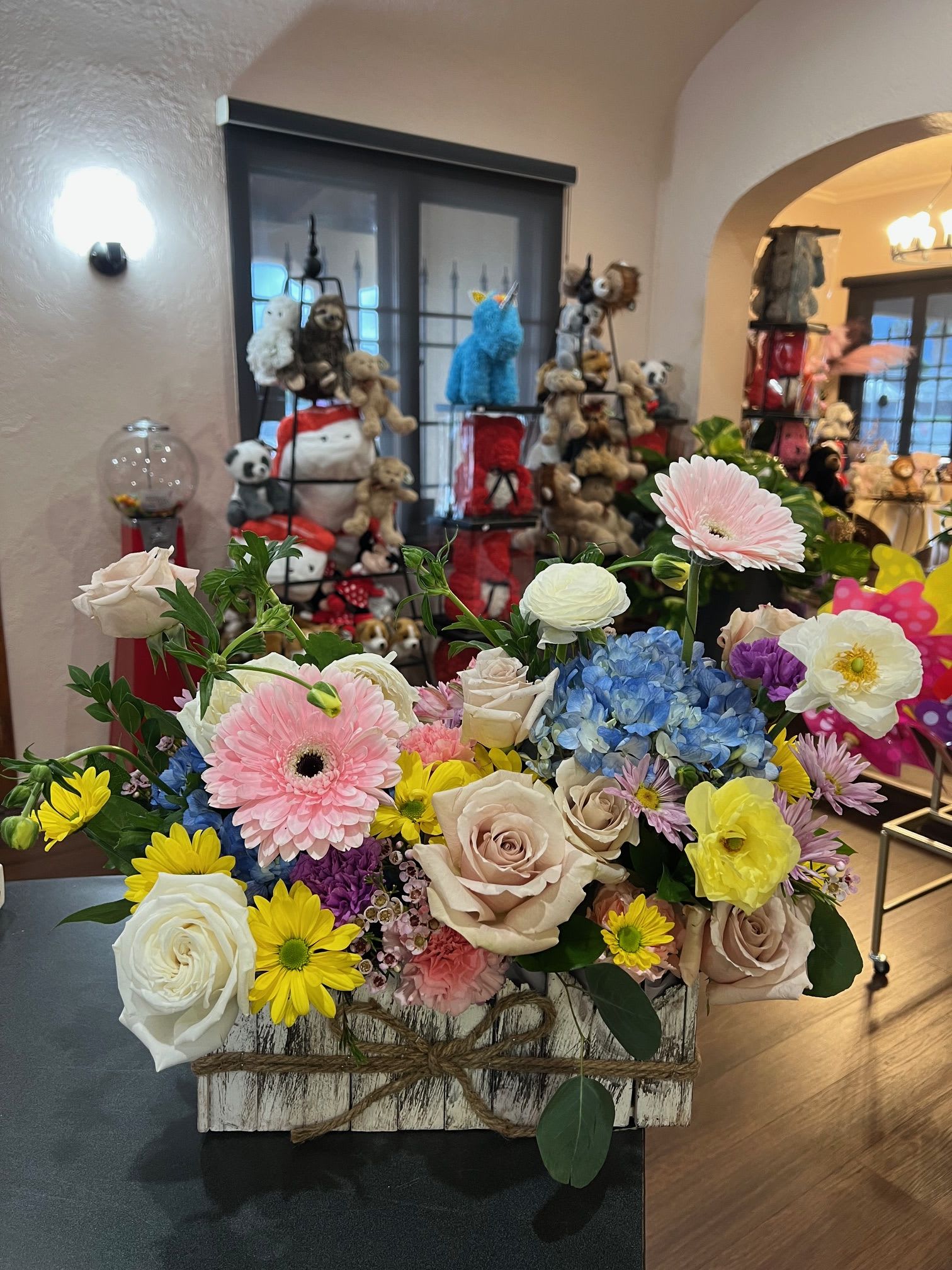 Mixed bouquet in a rustic wooden box with roses, gerbera daisies, hydrangea, and ranunculus