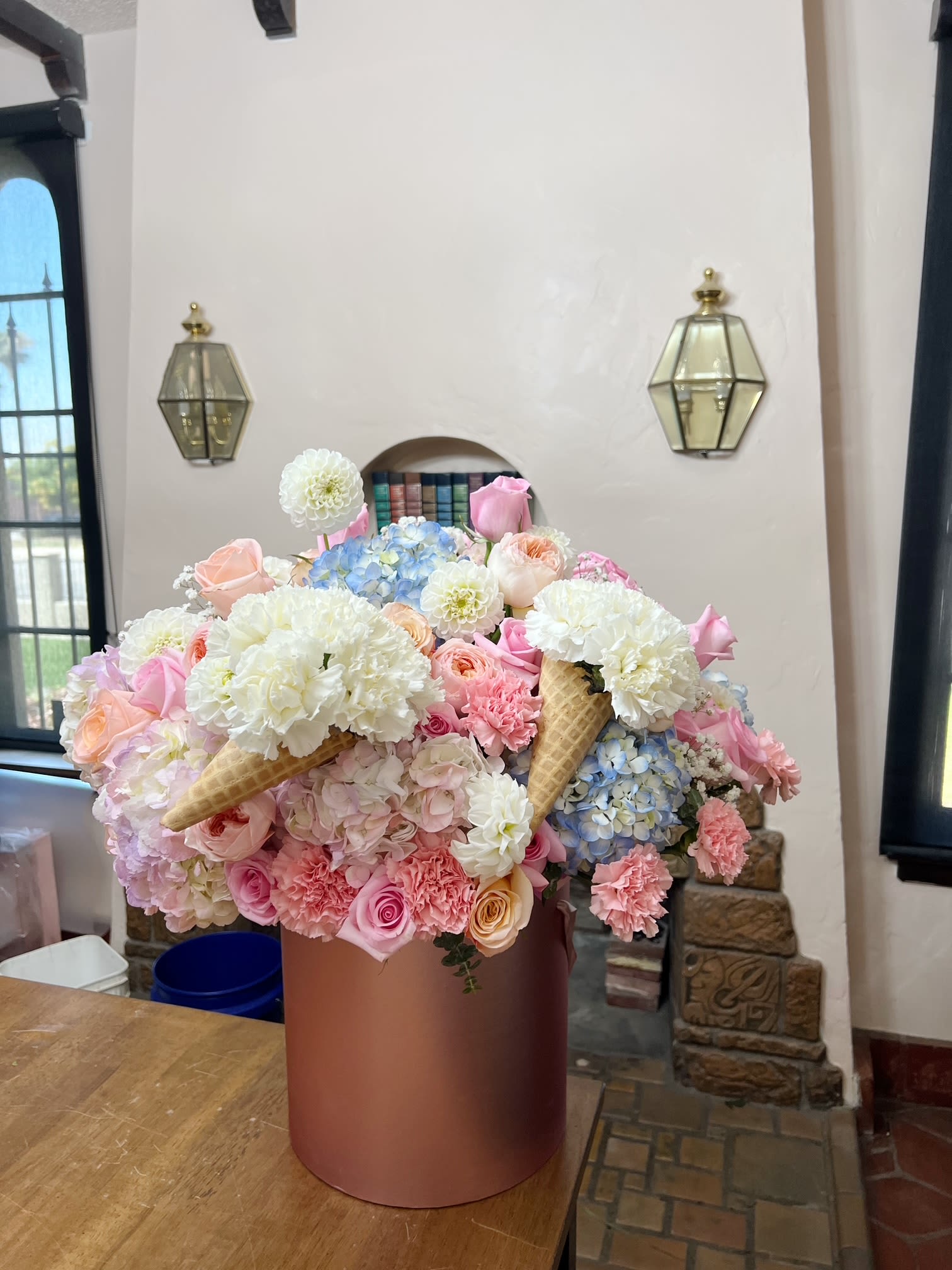 Large pastel flower arrangement in a round pink box with ice cream cone accents
