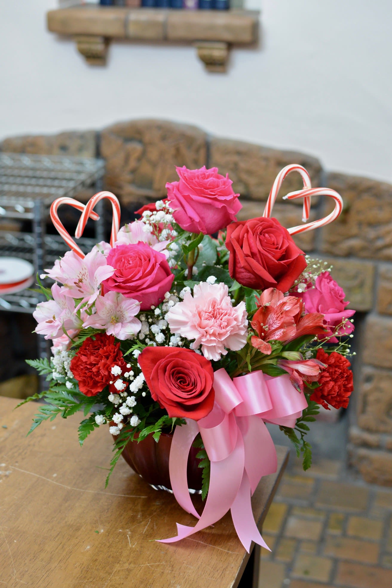 Candy-Heart Roses - A sweet and vibrant Valentine’s Day arrangement featuring red and hot pink roses, red and pink carnations, and cheerful alstroemeria, all beautifully gathered in a bold red vase. Inspired by classic candy hearts, this design is full of love, color, and Valentine cheer.