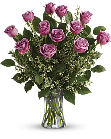 One dozen Lavender rose bouquet - A gorgeous greeting for any occasion this lovely lavender bouquet features one dozen radiant roses with lush greens in a classic glass vase.  standard: one dozen Deluxe: two dozen Premium: three dozen 