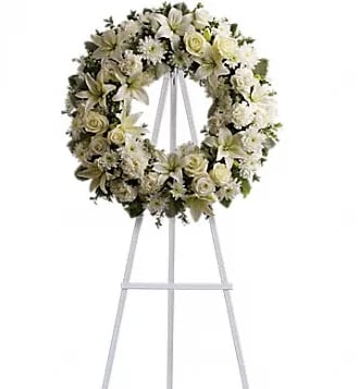 White floral funeral wreath on a standing easel