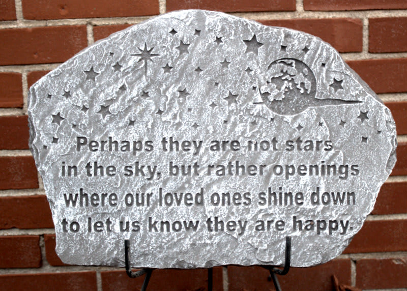 Decorative memorial stone plaque with a starry quote on a brick wall