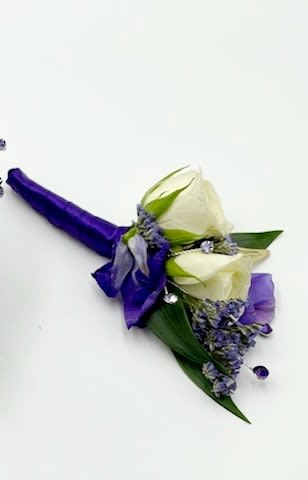 Tangled Boutonniere - A boutonniere  featuring white spray roses, dark purple larkspur, purple filler flowers, purple rhinestones, gold leaf accents with purple &amp; gold ribbon.