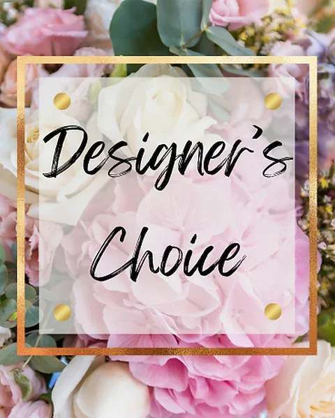 Pastel pink and white flowers with a transparent square sign reading 'Designer’s Choice' in black script