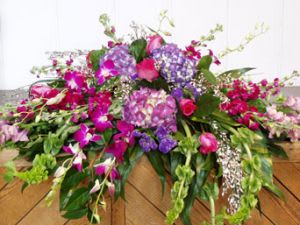 Large pink and purple floral arrangement with cascading blooms