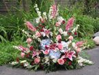 Large outdoor flower arrangement with pink lilies and mixed blooms