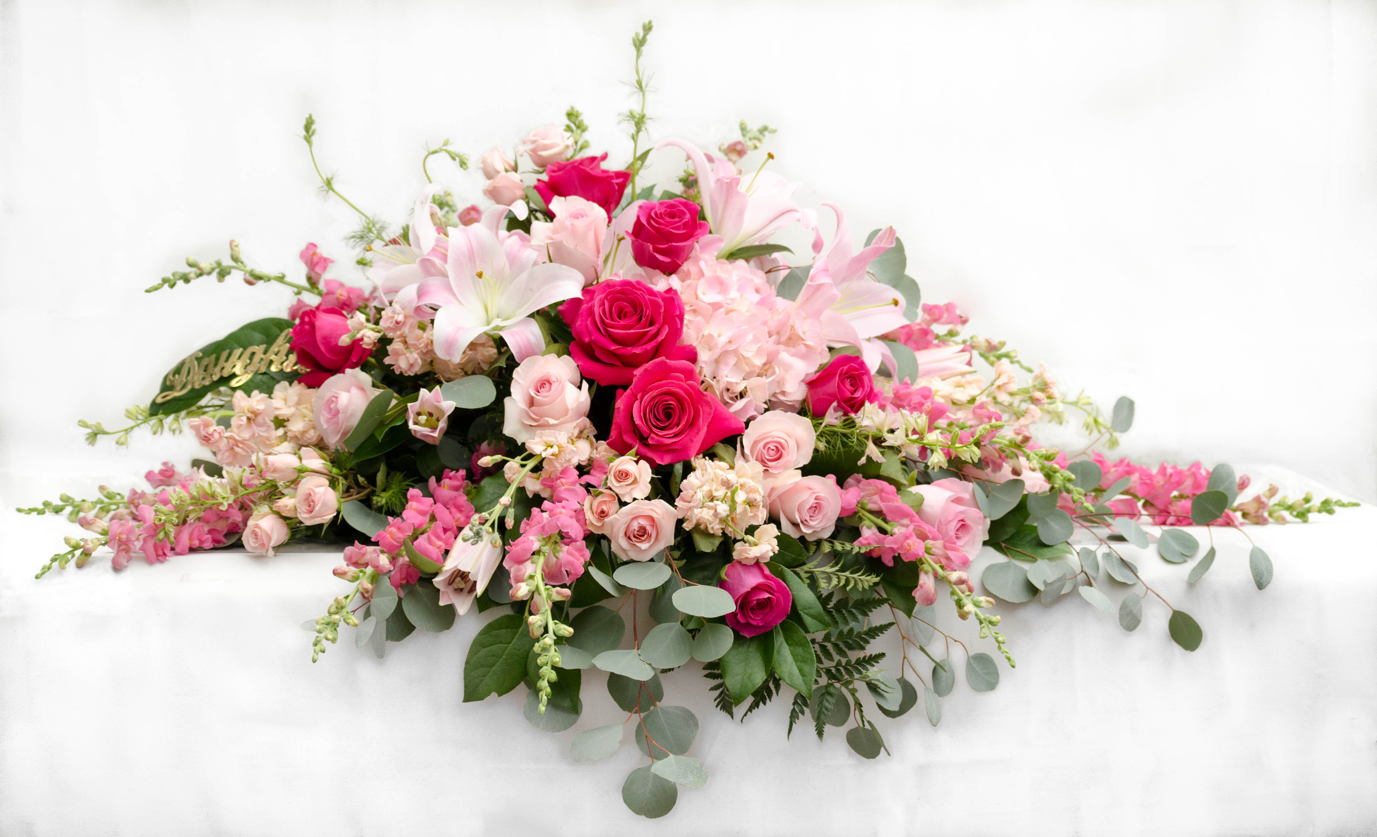 Pink and white floral casket spray with roses and lilies