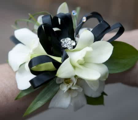 White orchid wrist corsage with black ribbon and rhinestone accents