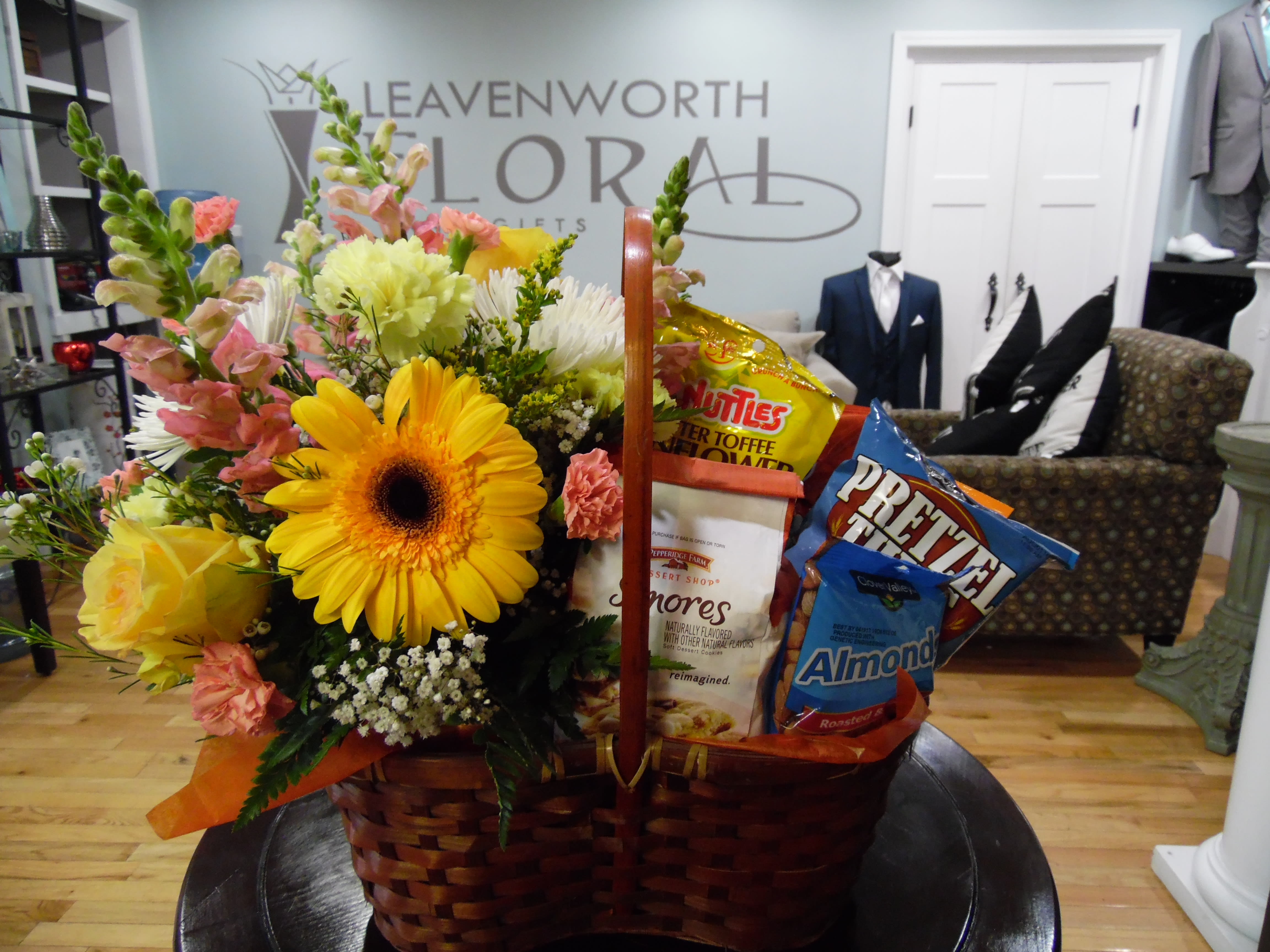 Basket arrangement with yellow flowers and snack bags
