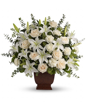 White lilies and cream roses arranged in a brown urn vase