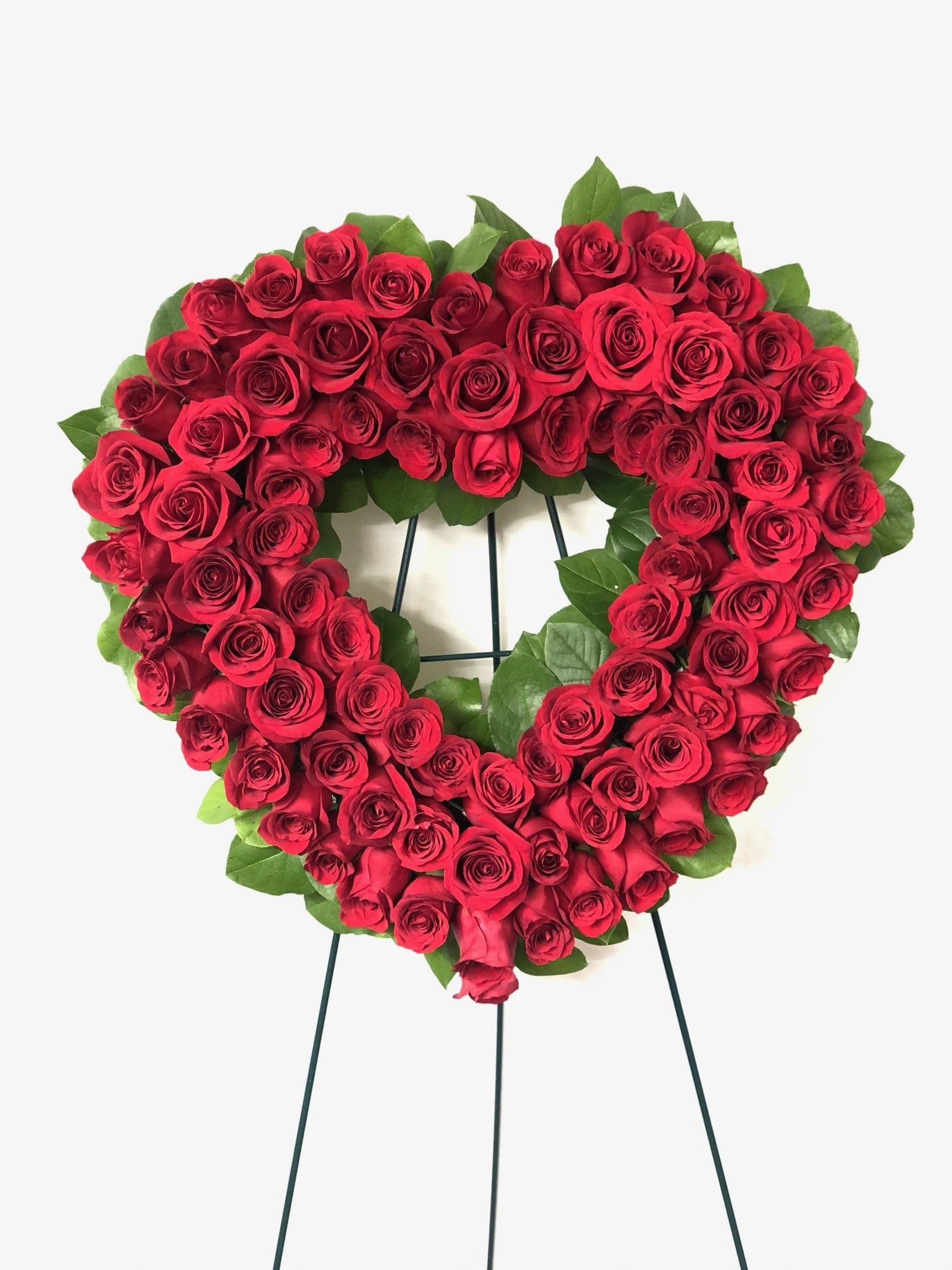 Heart-shaped wreath of red roses on a stand