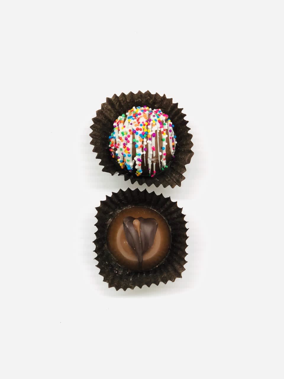 Two assorted chocolate truffles in brown paper cups on a white background