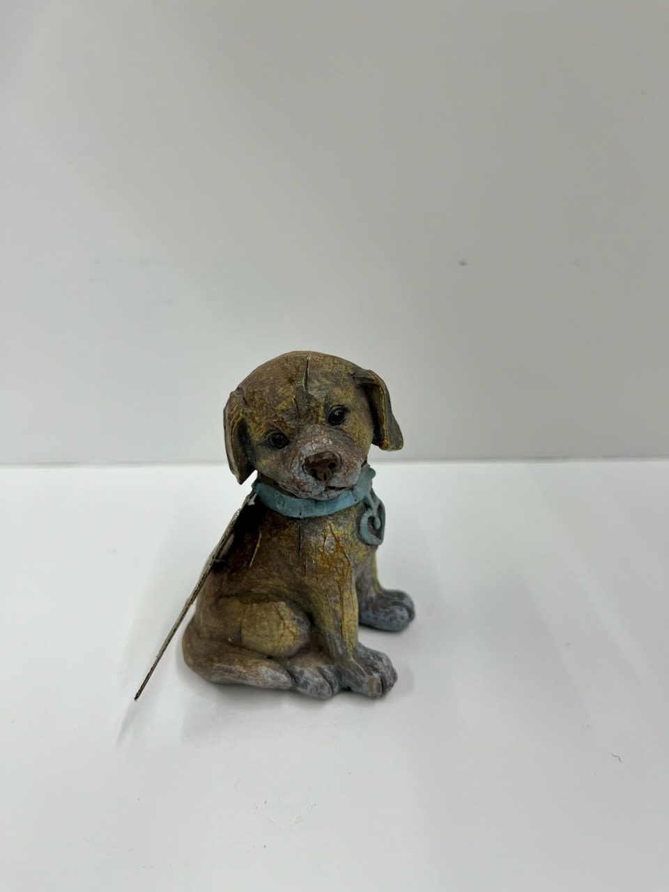 Small decorative dog figurine with a blue collar