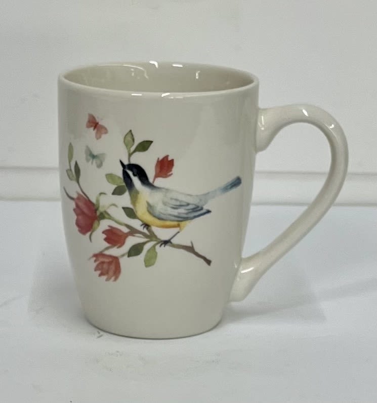 Cream ceramic mug with a bird and floral branch design
